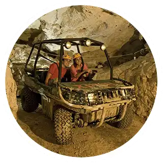 A couple venturing through the caverns by firelight in an amphibious vehicle