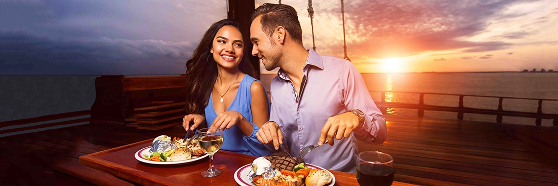 Couple enjoy a meal on the deck of the Columbus galleon