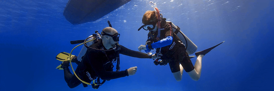 An instructor decends with a Jnr. Open Water Diver