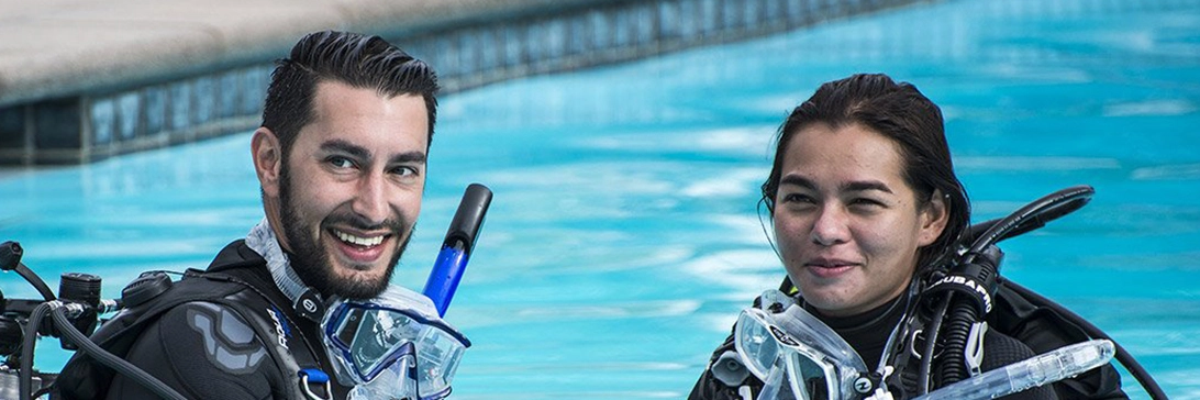 A couple smiles together as they begin their PADI refresher class
