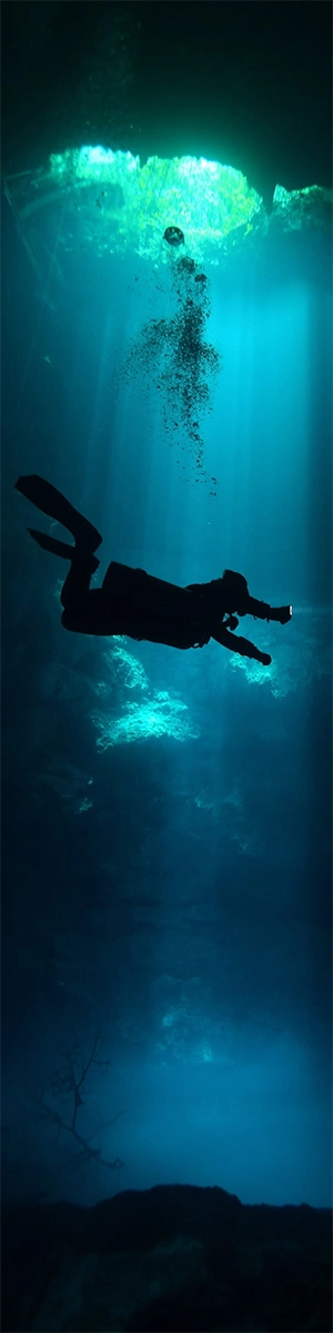 A diver decends into the cavern