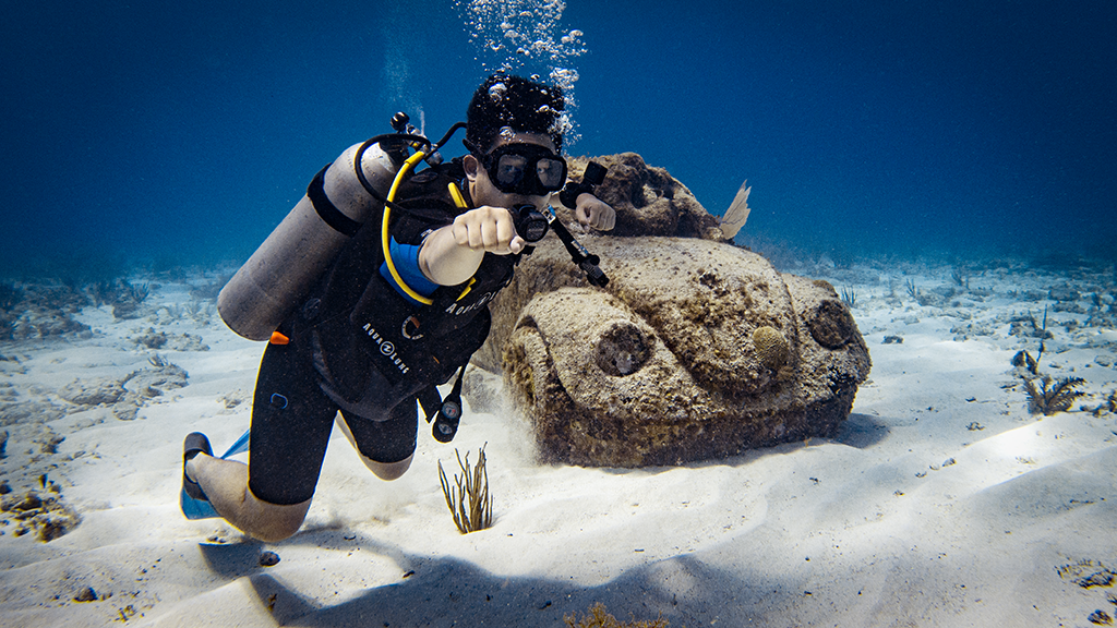 Diver swims next to VW sculpture at Musa