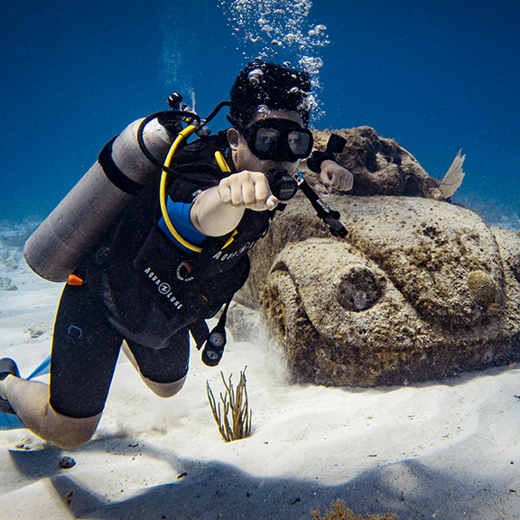 Diver swims next to VW sculpture at Musa