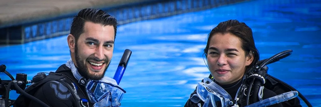 A couple smiles together as they begin their PADI refresher class